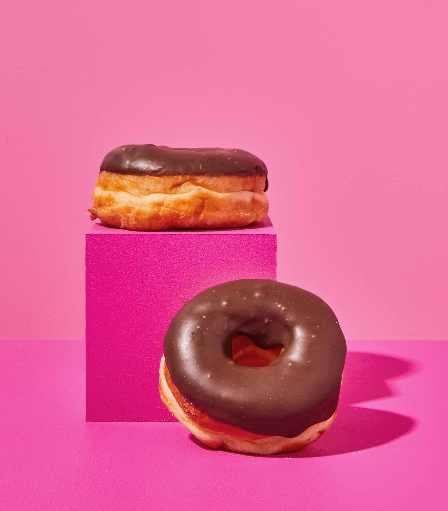 DOE Donuts stacked on a pink cube chocolate ganache filling